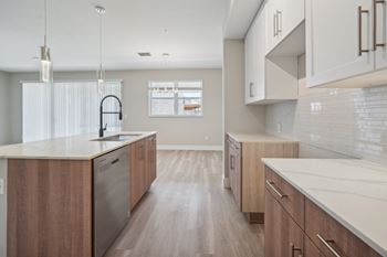 a large kitchen with wooden cabinets and white counter tops at The Falls of Portofino Apartment, Naples, FL